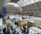 Busy trade exhibition hall with booths and visitors